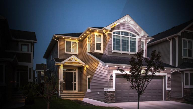 A house half illuminated with warm white and half illuminated with cool white LED lights.